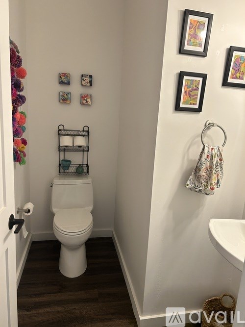 A white toilet in a bathroom with pictures on the wall.
