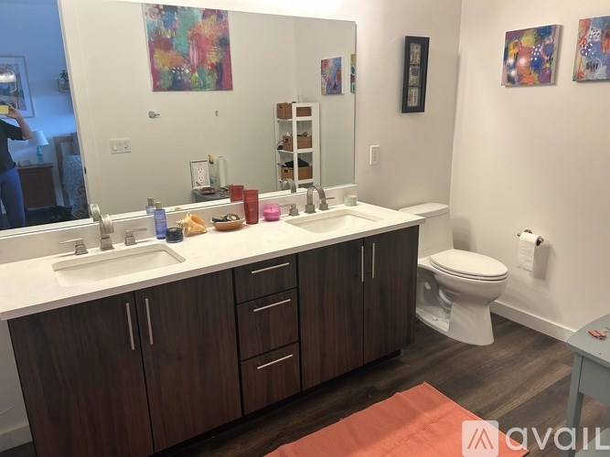 A bathroom with a white counter top and brown cabinets.