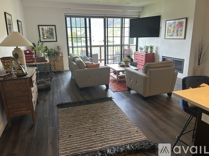 A living room with a fireplace and a flat screen TV mounted on the wall.