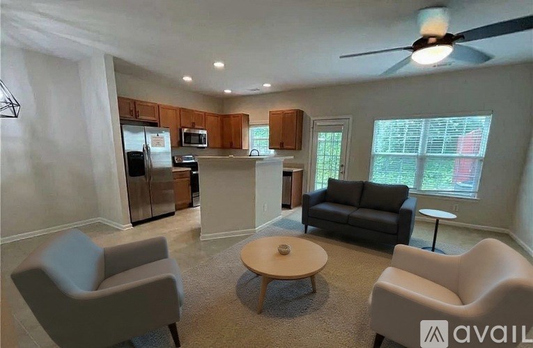 A living room with a grey couch, a coffee table, and a ceiling fan.