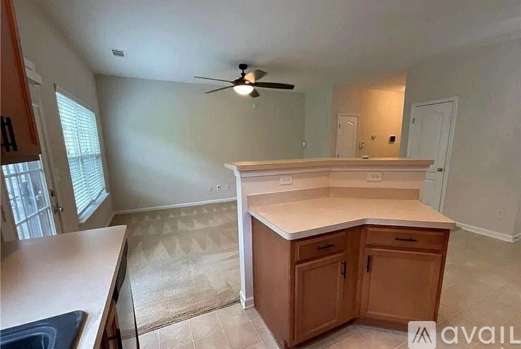 A kitchen with a counter and a fan.