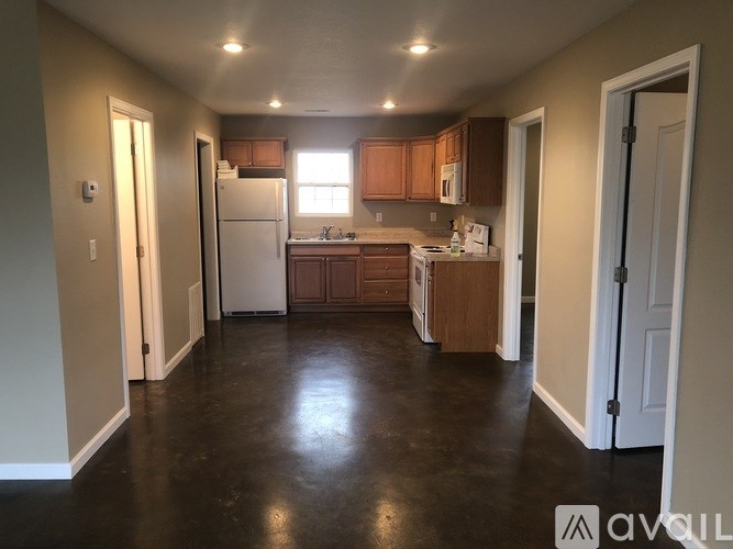 A kitchen with brown cabinets and a white fridge.