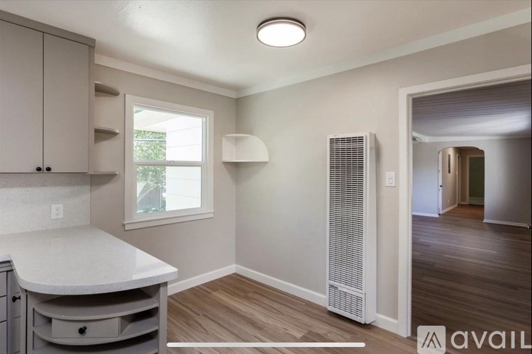 A kitchen area with a white countertop and a window.
