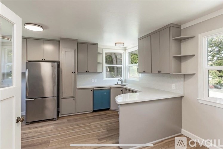 A kitchen with a refrigerator, cabinets, and a countertop.