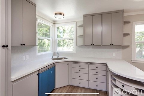 A kitchen with a blue cabinet and white countertops.