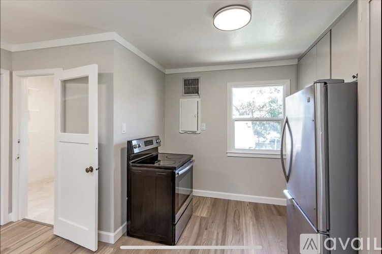 A kitchen with a fridge, oven, and dishwasher.