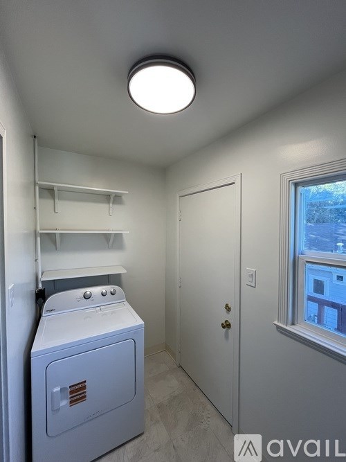 A small laundry room with a washer and dryer.