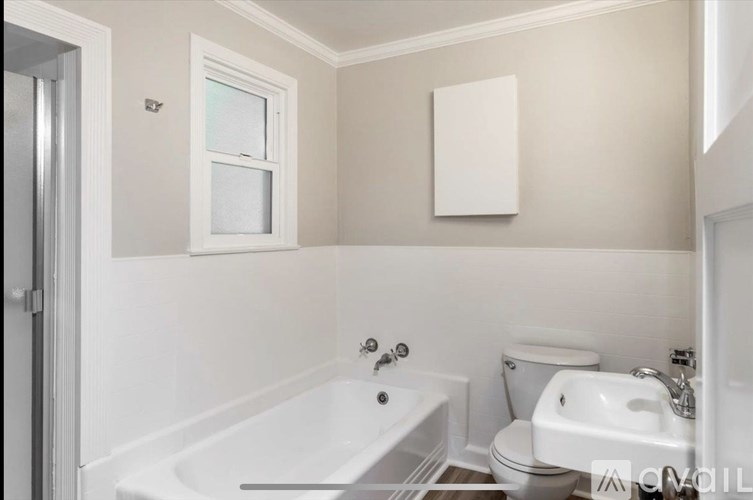 A white bathroom with a tub, toilet, and sink.
