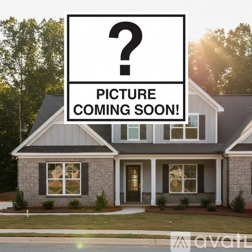A house with a sign that says "Picture Coming Soon!" in front of it.