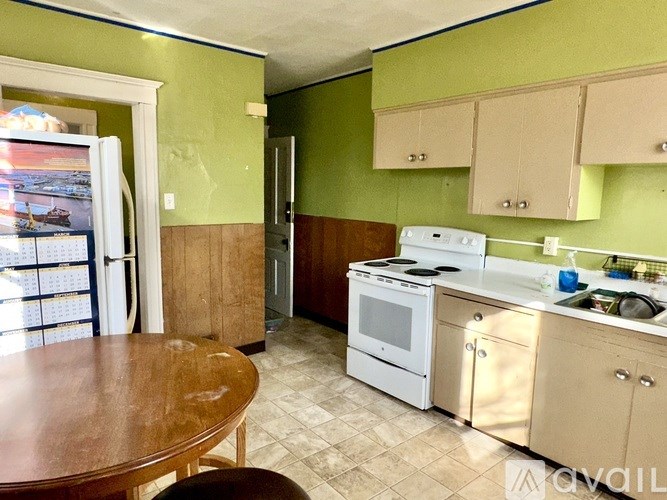 A kitchen with a table and chairs and a fridge.