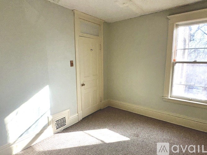 A room with a door, window, and carpet.
