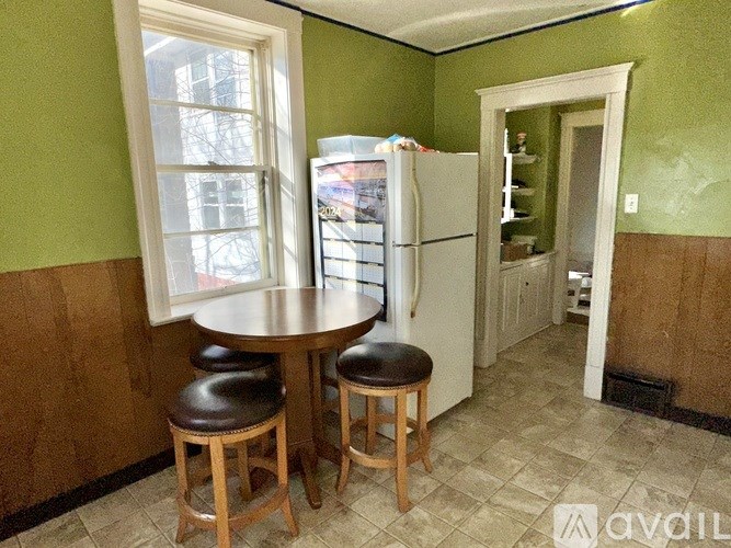 A kitchen with a green wall and a white fridge.