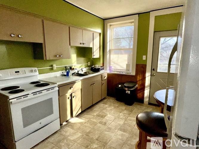 A kitchen with a white stove top oven and a white dishwasher.