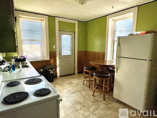 A kitchen with a white stove top oven and a white refrigerator.