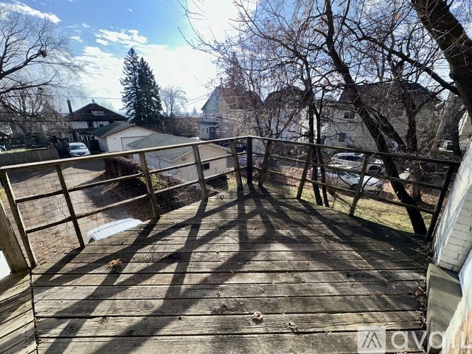 A wooden bridge in a residential area with houses in the background.