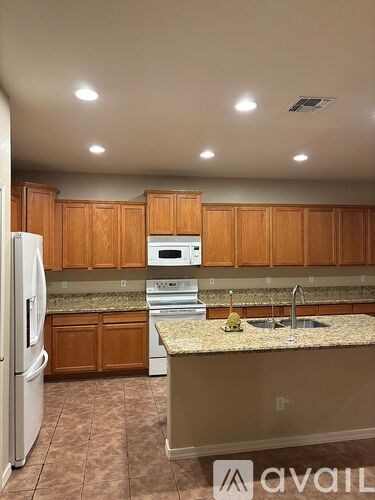A kitchen with brown cabinets and a granite countertop.