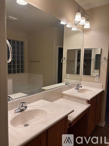 A bathroom with two sinks and a large mirror.