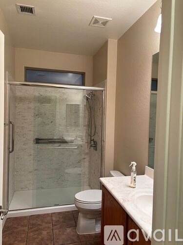 A bathroom with a toilet, sink, and walk-in shower.