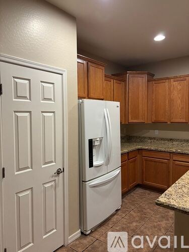 A kitchen with a white fridge and wooden cabinets.