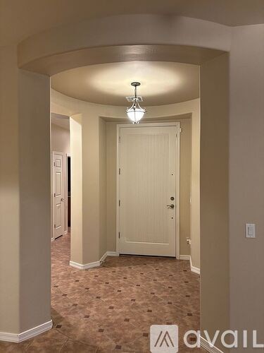 A hallway with a white door and a light fixture on the ceiling.