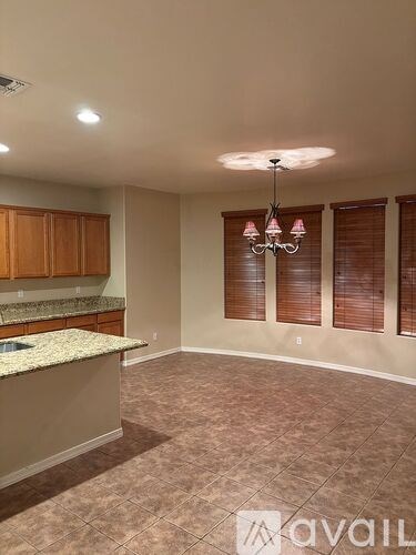 A kitchen with a granite countertop and wooden cabinets.