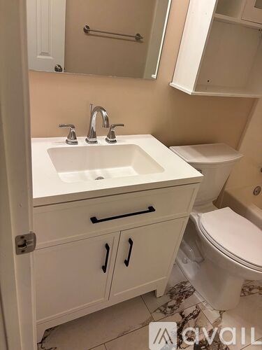 A white sink with a white toilet in a bathroom.