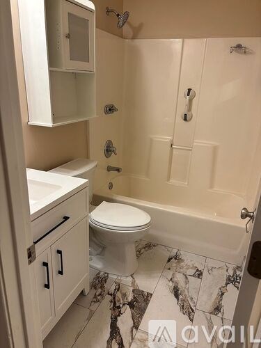 A white bathroom with a marble floor and a white toilet.