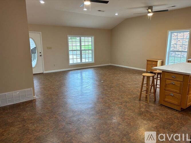 A spacious room with a bar area and a window.