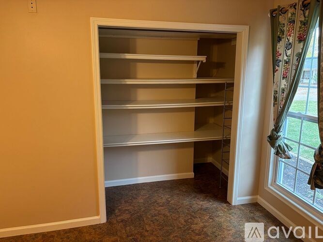 Empty shelves in a room with a window.