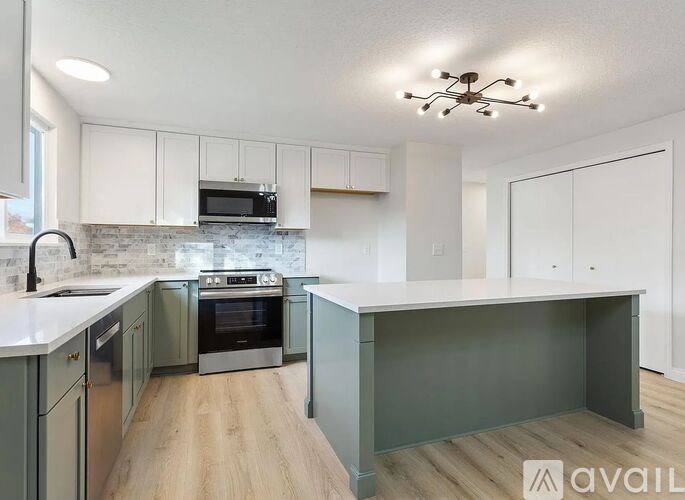 A kitchen with a white countertop and a grey island.