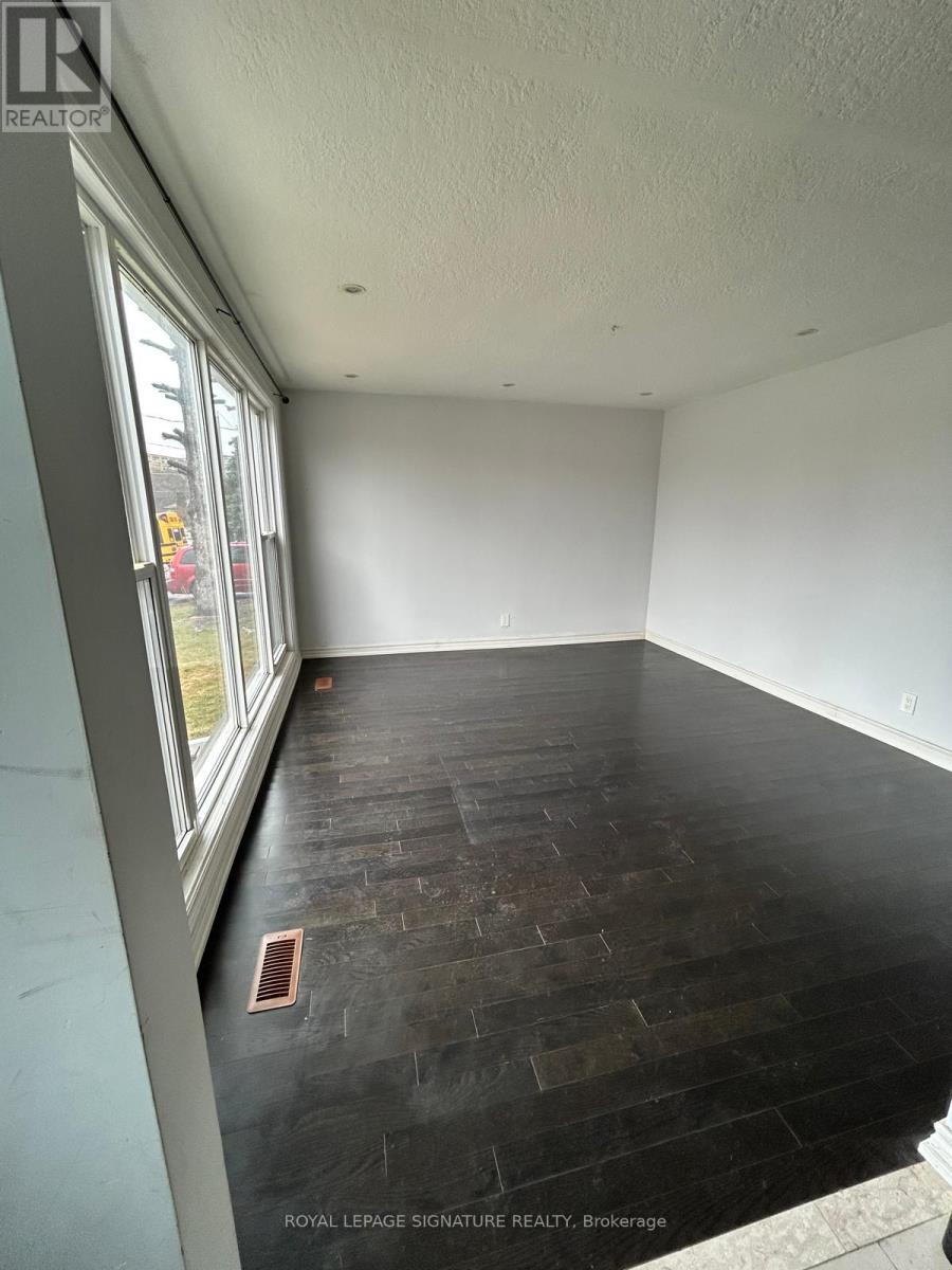 A room with a window and a wooden floor.