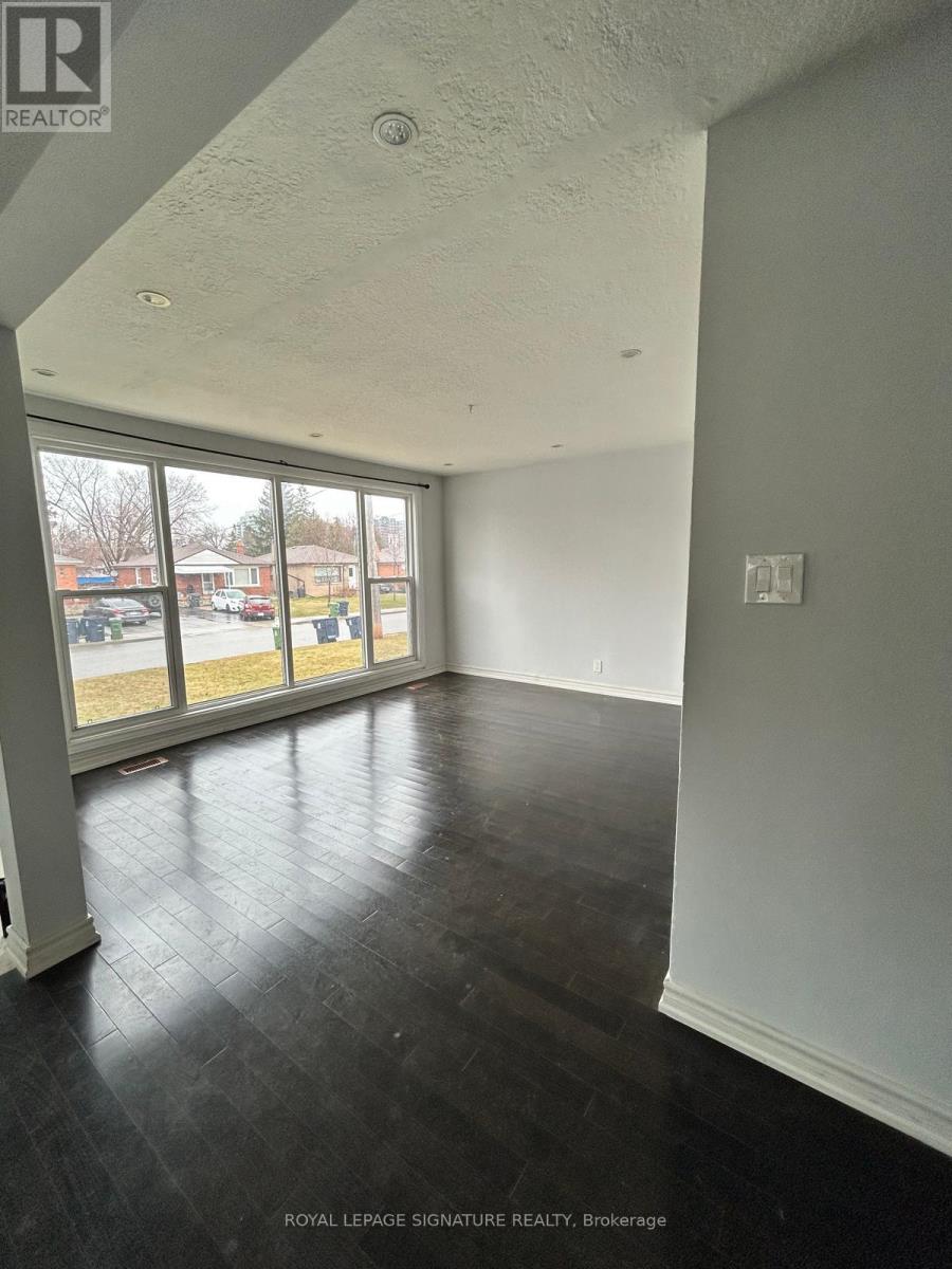 A room with a large window and a view of a parking lot.