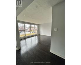 A room with a large window and a view of a parking lot.