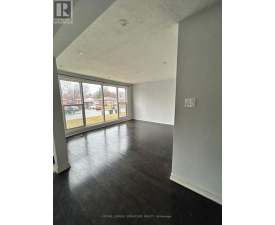 A room with a large window and a view of a parking lot.