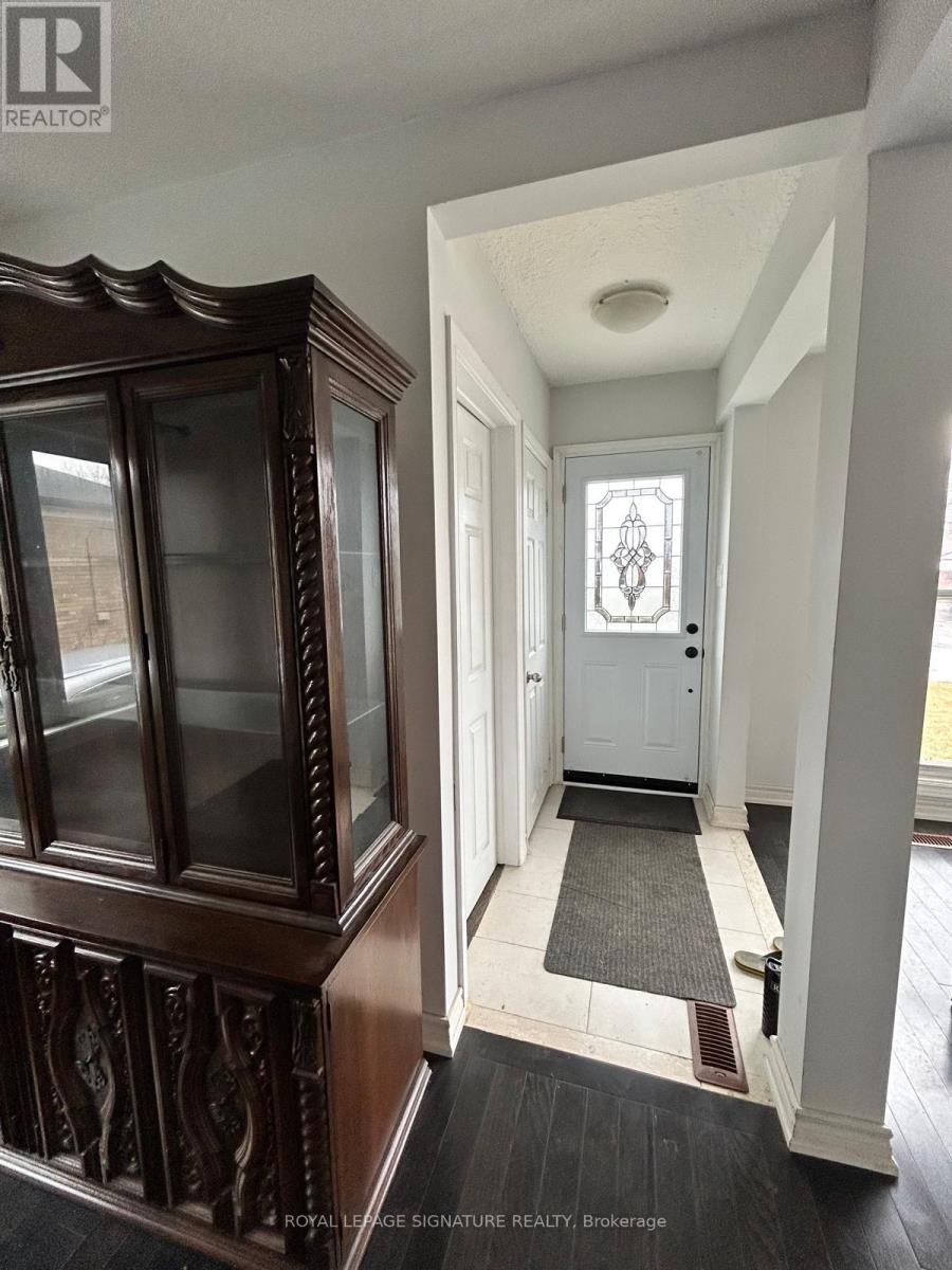 A hallway with a white door and a wooden cabinet.
