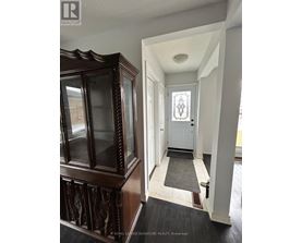 A hallway with a white door and a wooden cabinet.