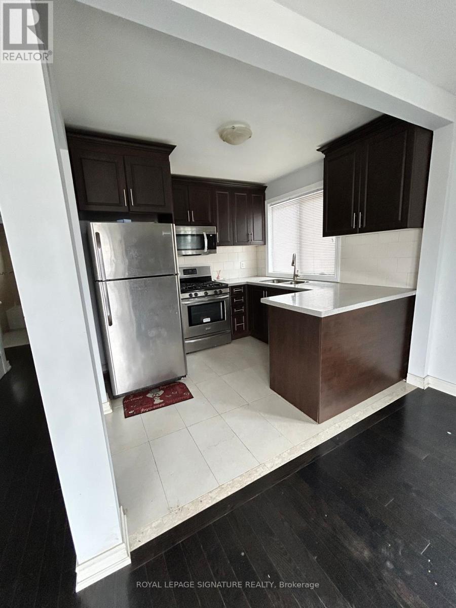 A kitchen with a refrigerator, stove, and sink.
