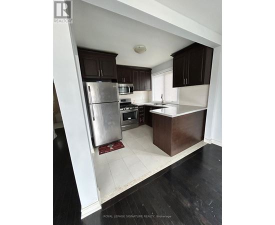 A kitchen with a refrigerator, stove, and sink.