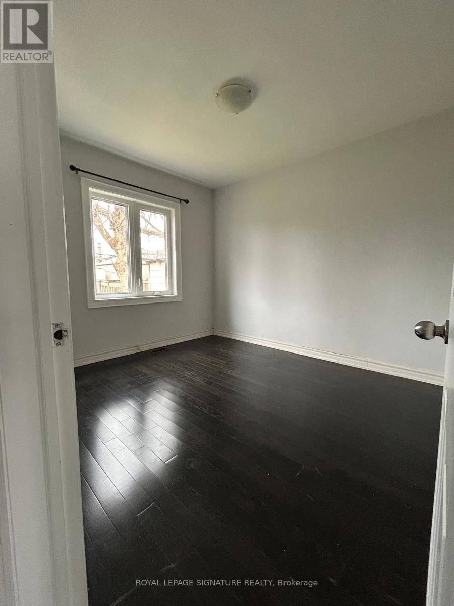 A room with white walls and black wooden flooring.