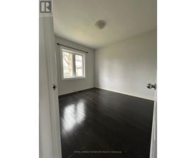 A room with white walls and black wooden flooring.
