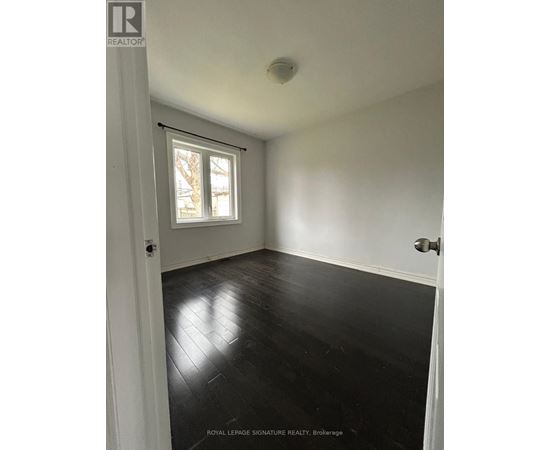 A room with white walls and black wooden flooring.