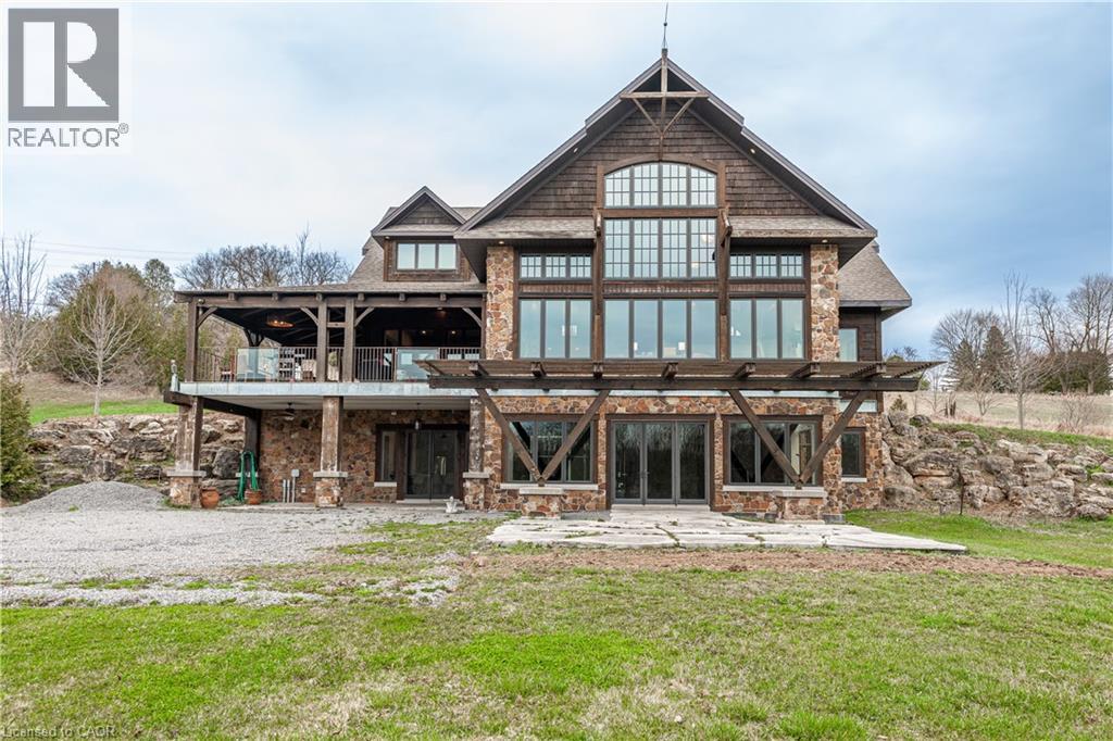 A large wooden house with a stone foundation and a stone chimney.