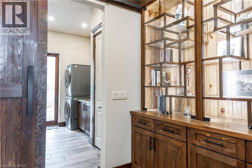 A modern kitchen with wooden cabinets and a glass block wall.