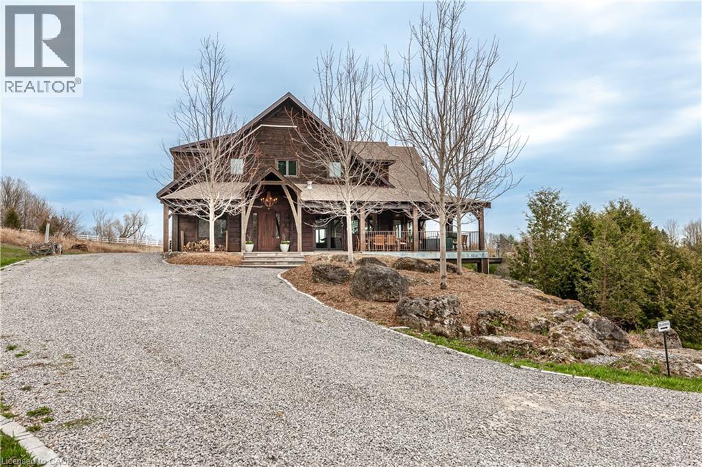 A large house with a gravel driveway in front.