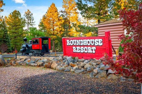 A sign that says Roundhouse Resort in front of a building.