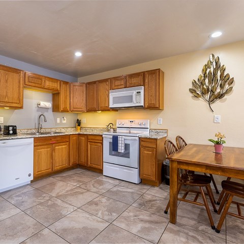 A kitchen with wooden cabinets and a white oven.