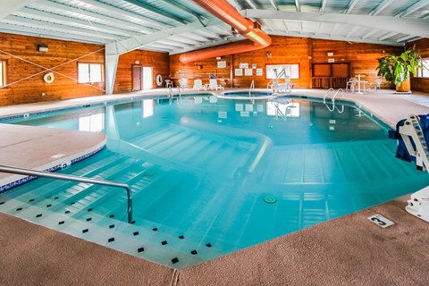 A large indoor swimming pool with a wooden wall and ceiling.