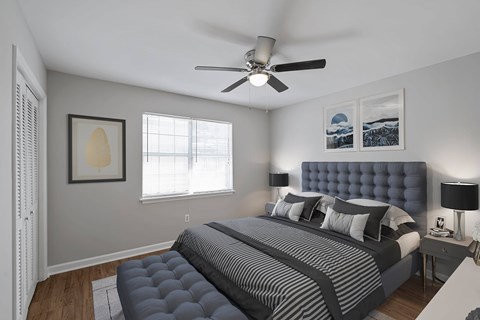 A bedroom with a large bed and a ceiling fan.