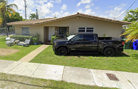 A black truck is parked in front of a house.