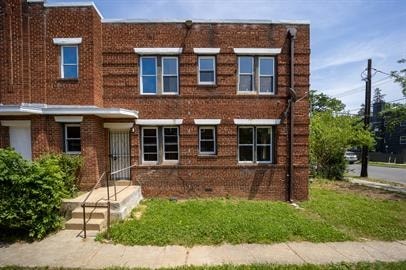 A red brick building with a white door and windows.